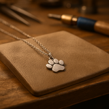 Graça - Elegante pingente prateado com estampa de pata em uma corrente.